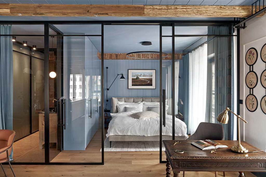 Stonowany, gołębi błękit, sypialnia oddzielona szklaną ścianką. Projekt Jan Sikora. Fot. Tom Kurek
