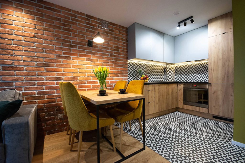 Kontrastujące ze sobą materiały i wzory na ścianie, podłodze oraz frontach szafek aneksu kuchennego to pomysł na wytyczenie wizualnej granicy między kuchnią a salonem_elkamino