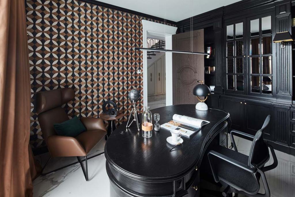 Przy okazji generalnego remontu domu właściciele zdecydowali się na renowację klasycznej zabudowy gabinetu. Solidne meble zyskały głębszy, ciemniejszy kolor oraz lustrzane wypełnienia frontów. Do kompletu powstało biurko o nietypowym zaokrąglonym kształcie. By ożywić aranżację i dodać jej przytulności, architektka wybrała tapetę z geometrycznym wzorem w ciepłych odcieniach ziemi.