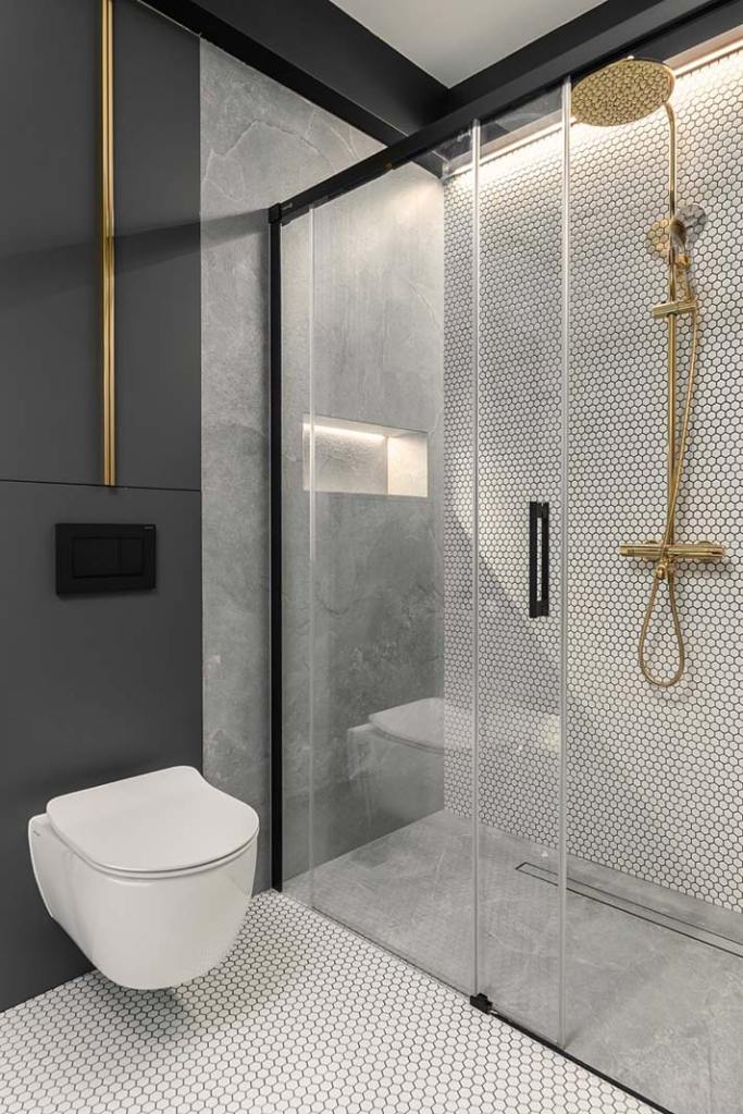 Poszukując pomysłów na schowki w łazience projektantka Sandra Białkowska z pracowni projektowej Dobry Układ miejsce do przechowywania wygospodarowała w zabudowie nad podwieszaną toaletą. To najlepszy sposób na wykorzystanie przestrzeni powstałej nad wiszącym stelażem wc.