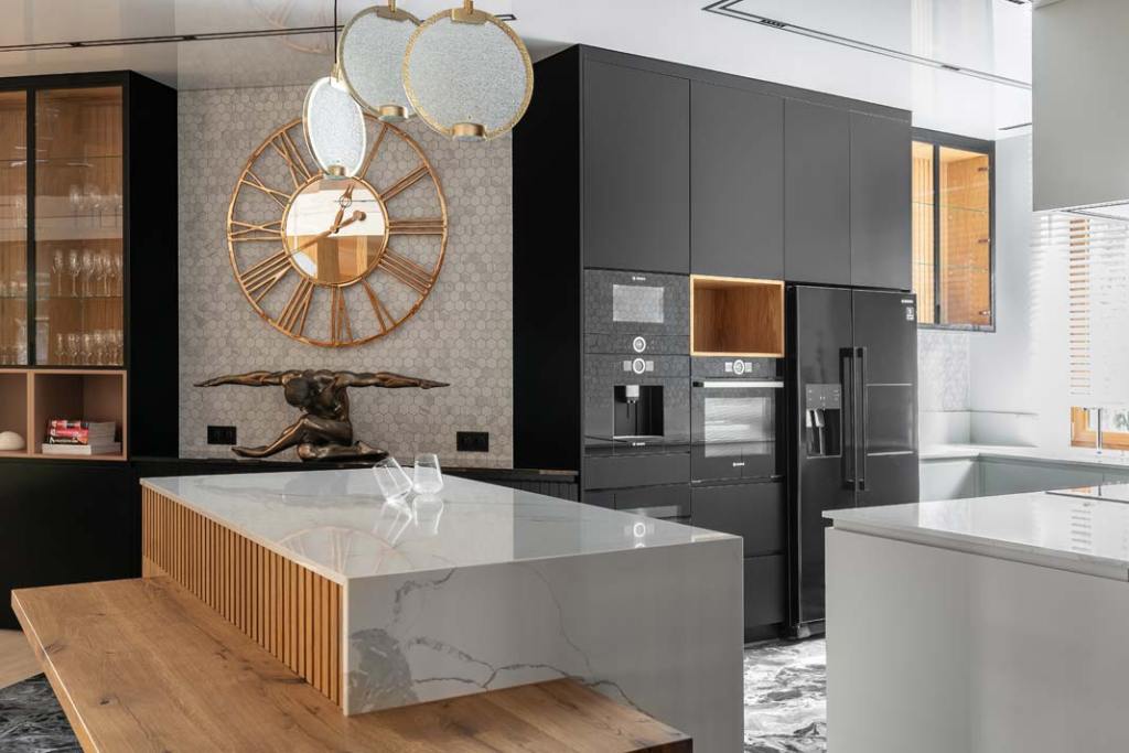 cz-dzienna_kuchnia_nowoczesne glamour, widok na kuchnię - wysoka zabudowa w czarnym kolorze i jasna wyspa kuchenna z elementami ryflowanego drewna